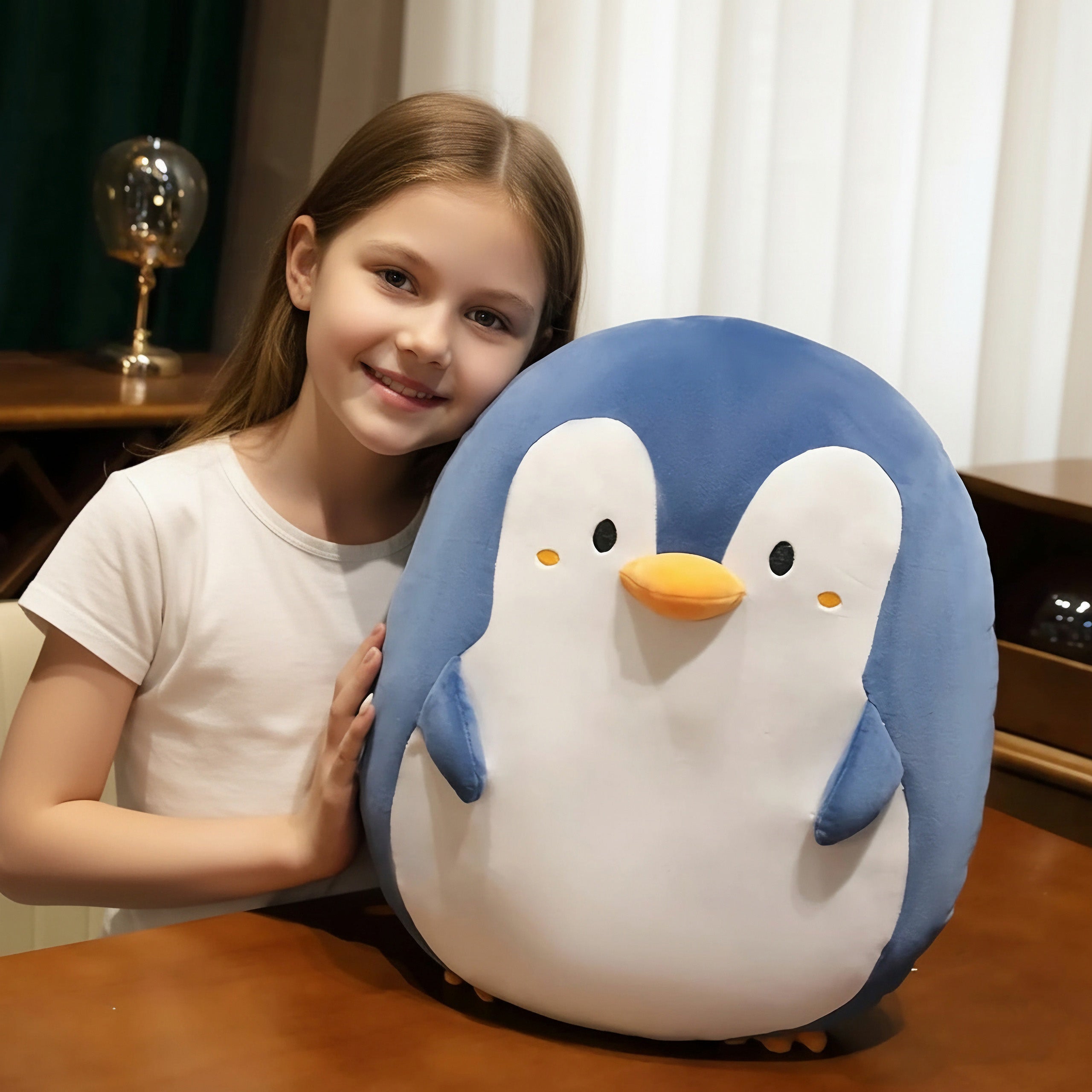 Girl smiling and holding a large plush penguin pillow indoors, a gift-style shot