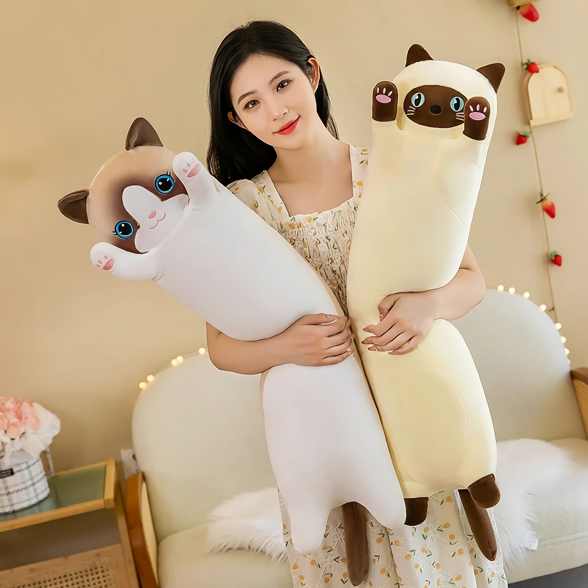 Woman holding two extra-long plush cat toys in a cozy indoor setting