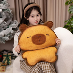 Woman holding a bread capybara plush in front of a Christmas tree