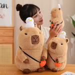 Woman smiling beside capybara plushies with white ducks on their heads
