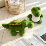 Three green alligator plush toys with cream bellies on a cream rug beside a wicker basket