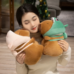 Woman holding two capybara plushies wearing pig and dinosaur hoods
