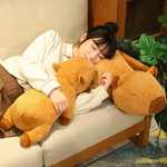 Woman sleeping on a sofa hugging two lying capybara plush pillows