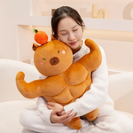 Woman hugging a muscle capybara plush with a small orange on its head