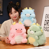 A woman smiling with pink, blue, and green pig-dragon plush cushions on a table.