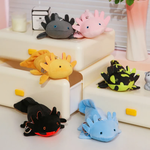 Six axolotl plushies in black, pink, yellow, spotted green, blue and gray on a white shelf