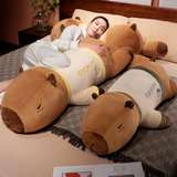 Woman sleeping on a bed with lying capybara plush pillows in cream shirts