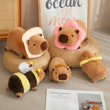 Capybara plushies in bread, flower and bee costumes on a woven stool