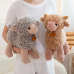 Woman holding a brown and a gray curly lamb plush in front of a white sofa