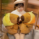 Woman holding two capybara plushies in orange and pineapple hoods