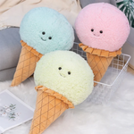 Blue, pink and mint green ice cream cone plush pillows with smiling faces on a fluffy white rug