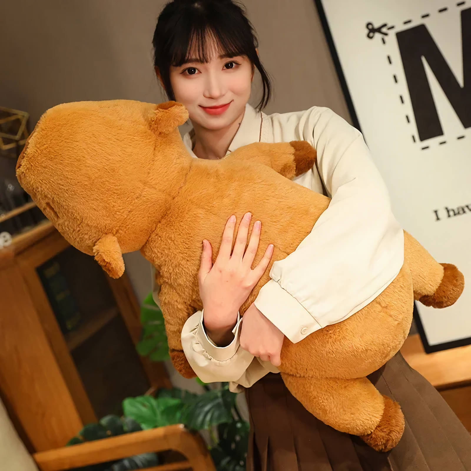 Woman hugging a large lying capybara plush pillow