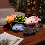 Pile of colorful axolotl plushies in yellow, spotted green, pink, blue, black and gray on a wooden table