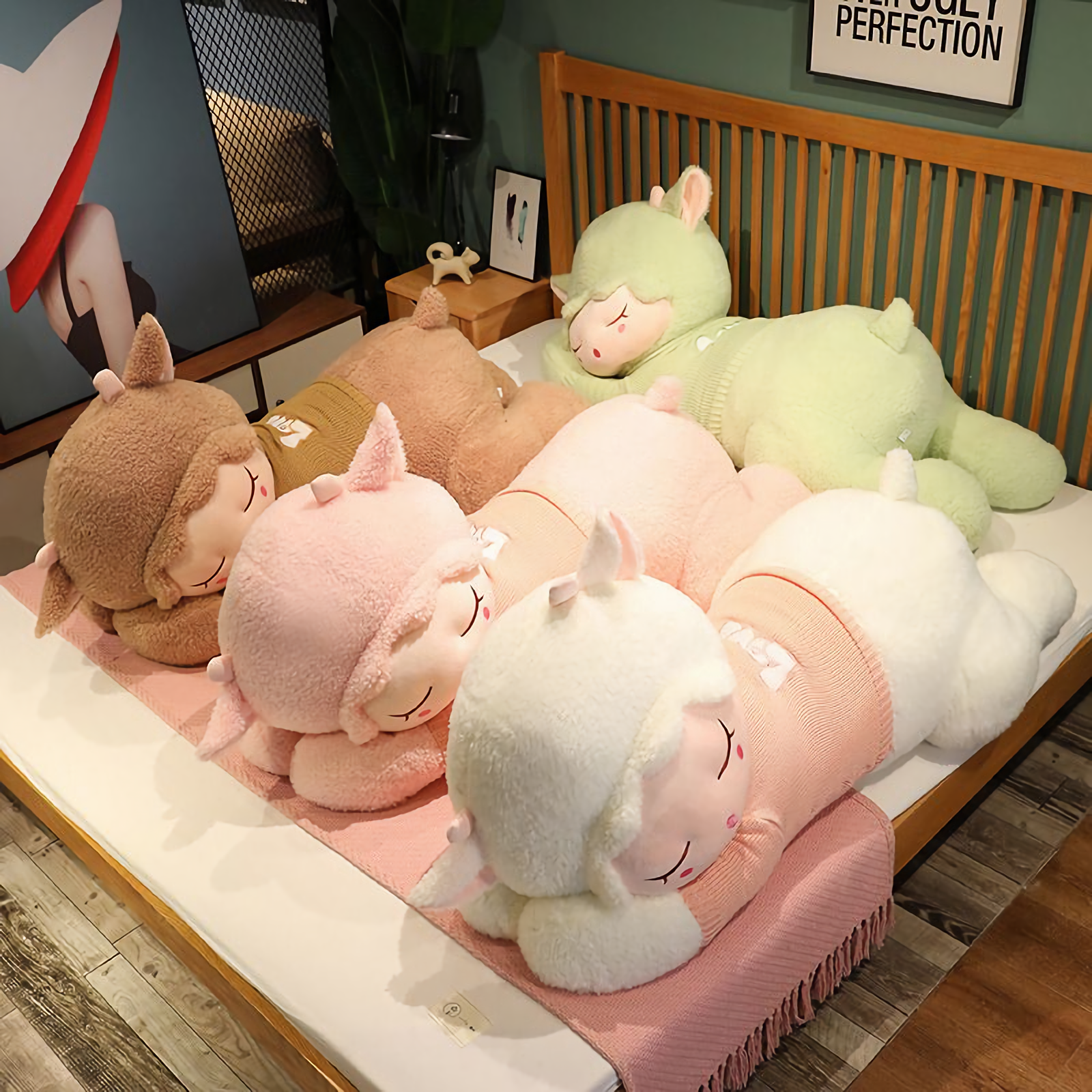 Sleeping sheep plush pillows in brown, pink, white and green lying together on a bed
