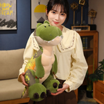 Woman holding green cartoon T-Rex dinosaur plush with belly patches, in a cozy room setting.