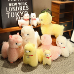 Group of pink, white and yellow alpaca plushies with red collars on a shelf and a rug