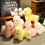 Group of pink, white and yellow alpaca plushies with red collars on a shelf and a rug