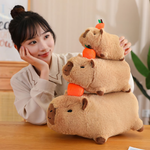 Woman resting her chin next to a stack of three lying capybara plushies with oranges