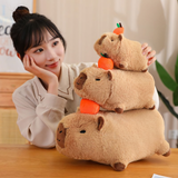 Woman resting her chin next to a stack of three lying capybara plushies with oranges