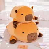 Two chubby capybara plush pillows stacked on a white bed