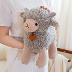 Woman holding a gray curly lamb plush against her white top