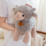 Woman holding a gray curly lamb plush against her white top