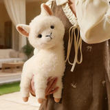 Woman in a brown dress holding a white fluffy alpaca plush