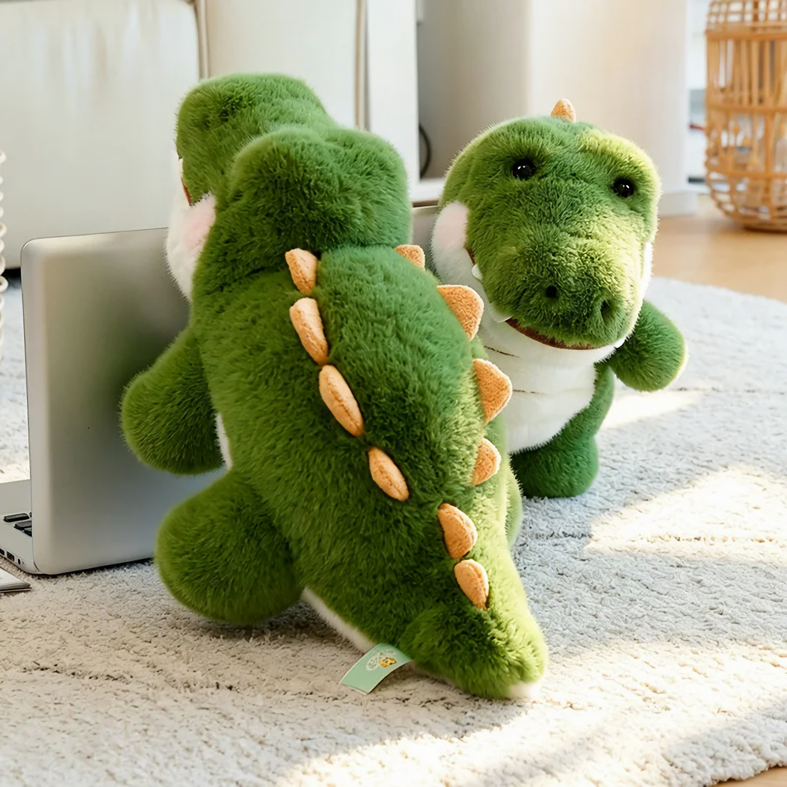 Green alligator plush toys on a rug next to a laptop