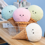 Four ice cream cone plush pillows in blue, pink, mint green and white on a wooden table