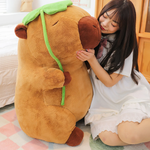 Woman hugging a big capybara plush holding a green lotus leaf