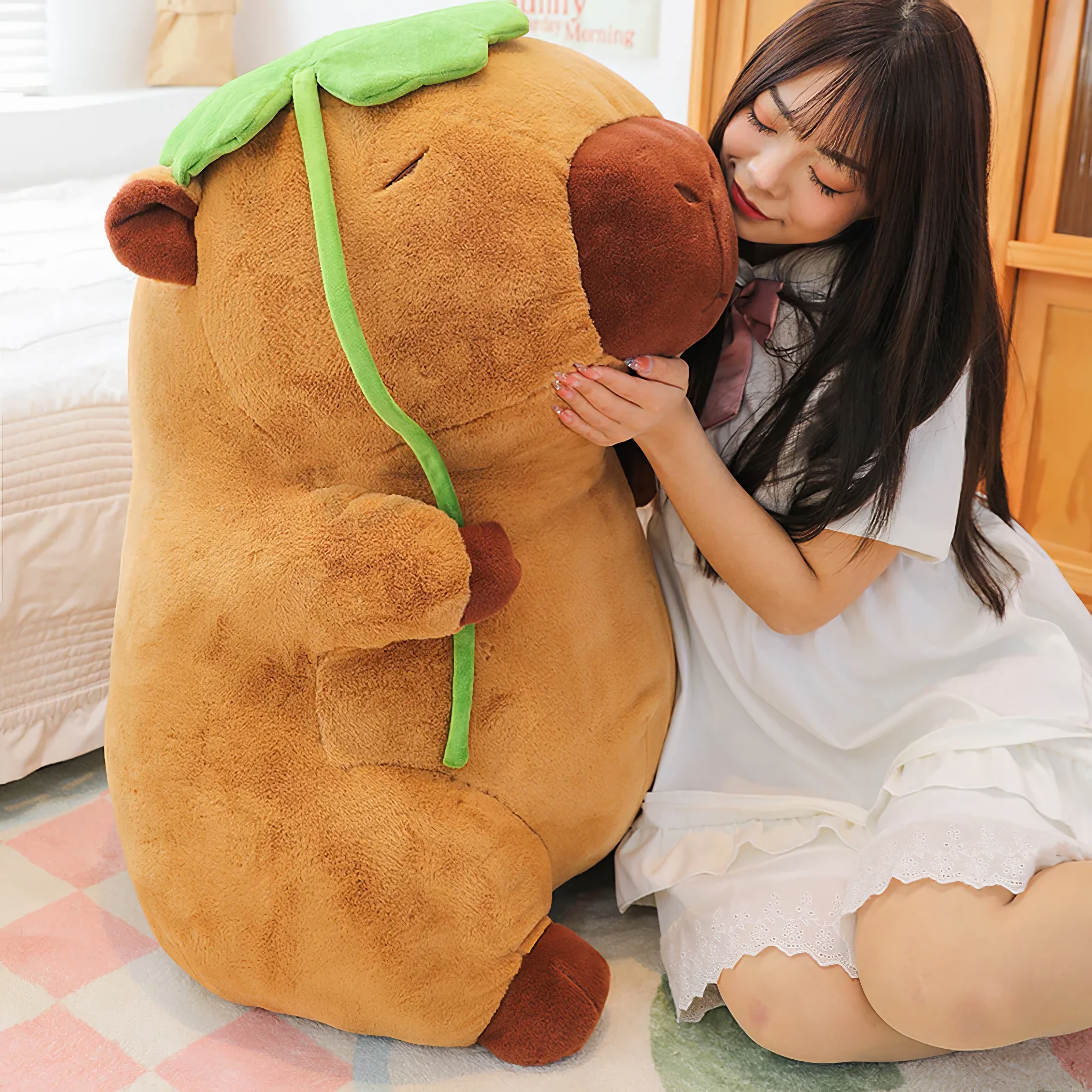 Woman hugging a big capybara plush holding a green lotus leaf