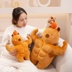 Woman sitting on a sofa with two muscle capybara plushies in different sizes