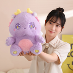 Woman holding a purple baby dragon plush with golden horns, sparkly star eyes, and a pink belly.