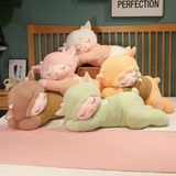 Group of sleeping sheep plush pillows in brown, pink, orange, green and white stacked on a bed