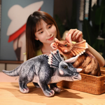 Woman adjusting brown Triceratops plush in basket, gray plush on table, both detailed and lifelike.