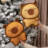 Hand holding a bread capybara plush next to another bread capybara plush