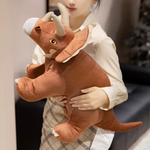 Woman holding a large brown Triceratops plush dinosaur, showing stitched details.