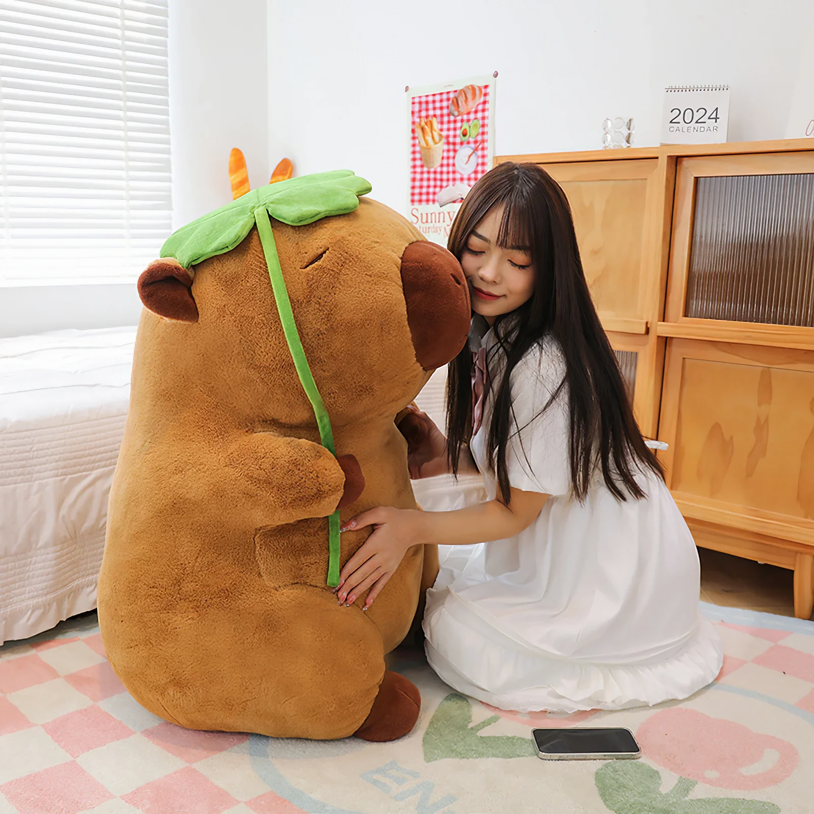 Woman kneeling and hugging a big capybara plush with a lotus leaf