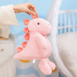 Hand lifting a pink dinosaur plush by its spike with a bedroom in the background