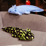 Blue axolotl plush lying on a gray sofa above a black and lime green spotted axolotl plush