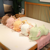 Five sleeping sheep plush pillows in sweaters lined up on a white bed