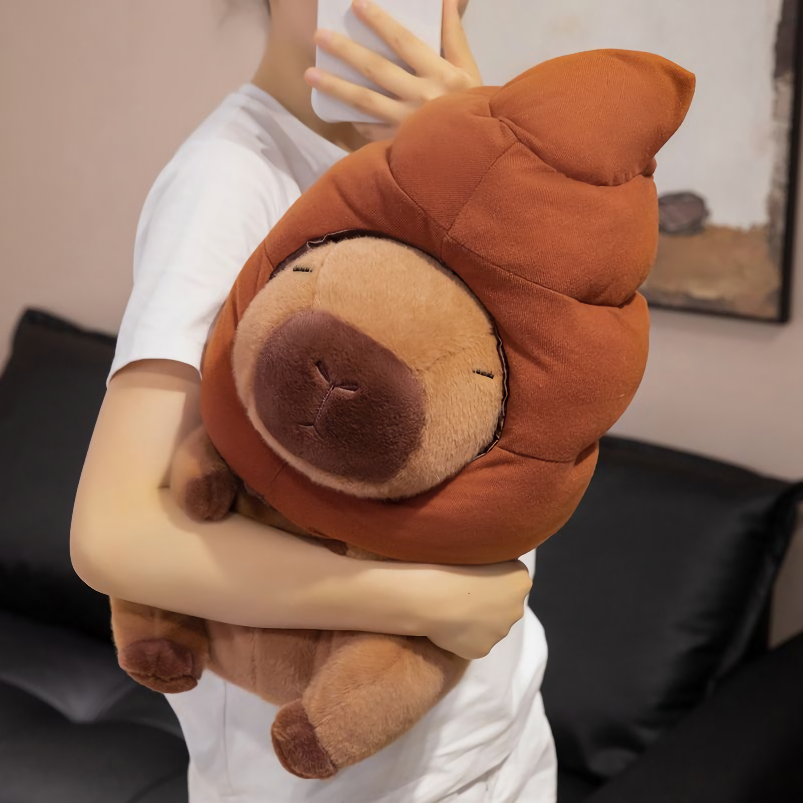 Woman hugging a capybara plush with a brown swirl hat