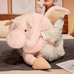 Woman hugging a large pink dragon plush with a small horn and soft wings