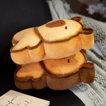 Two bread capybara plushies stacked on a sofa