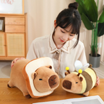 Woman with a bread capybara plush and a bee capybara plush on a table
