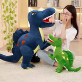 Woman with glasses beside a blue Spinosaurus plush and a green Spinosaurus plush