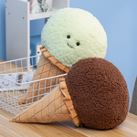 Mint green and brown ice cream cone plush pillows leaning on a white wire basket