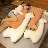Woman lying on a bed with white and brown long alpaca plush pillows