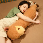 Woman lying on a bed hugging a long brown alpaca plush