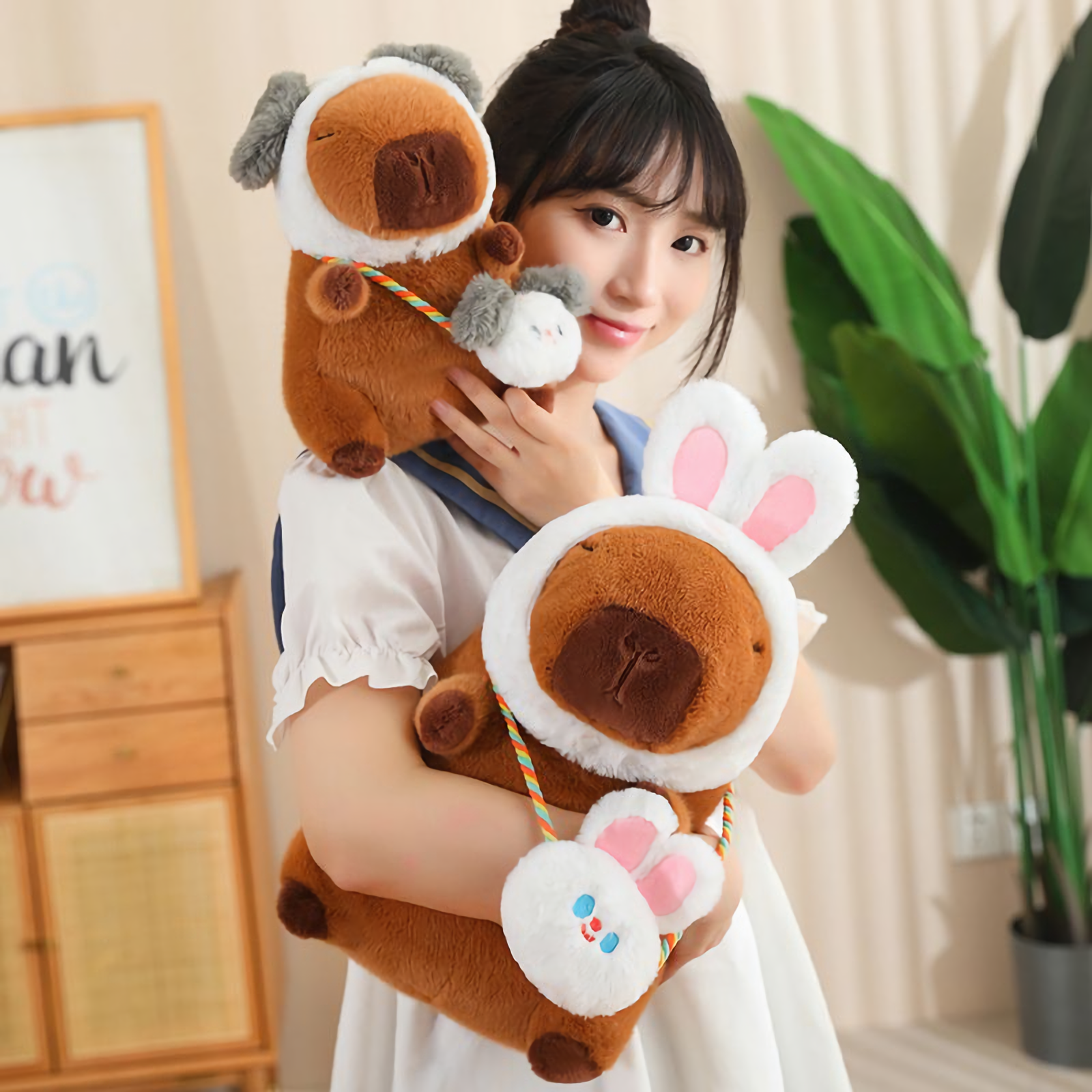 Woman hugging capybara plushies in rabbit and dog hoods with matching bags